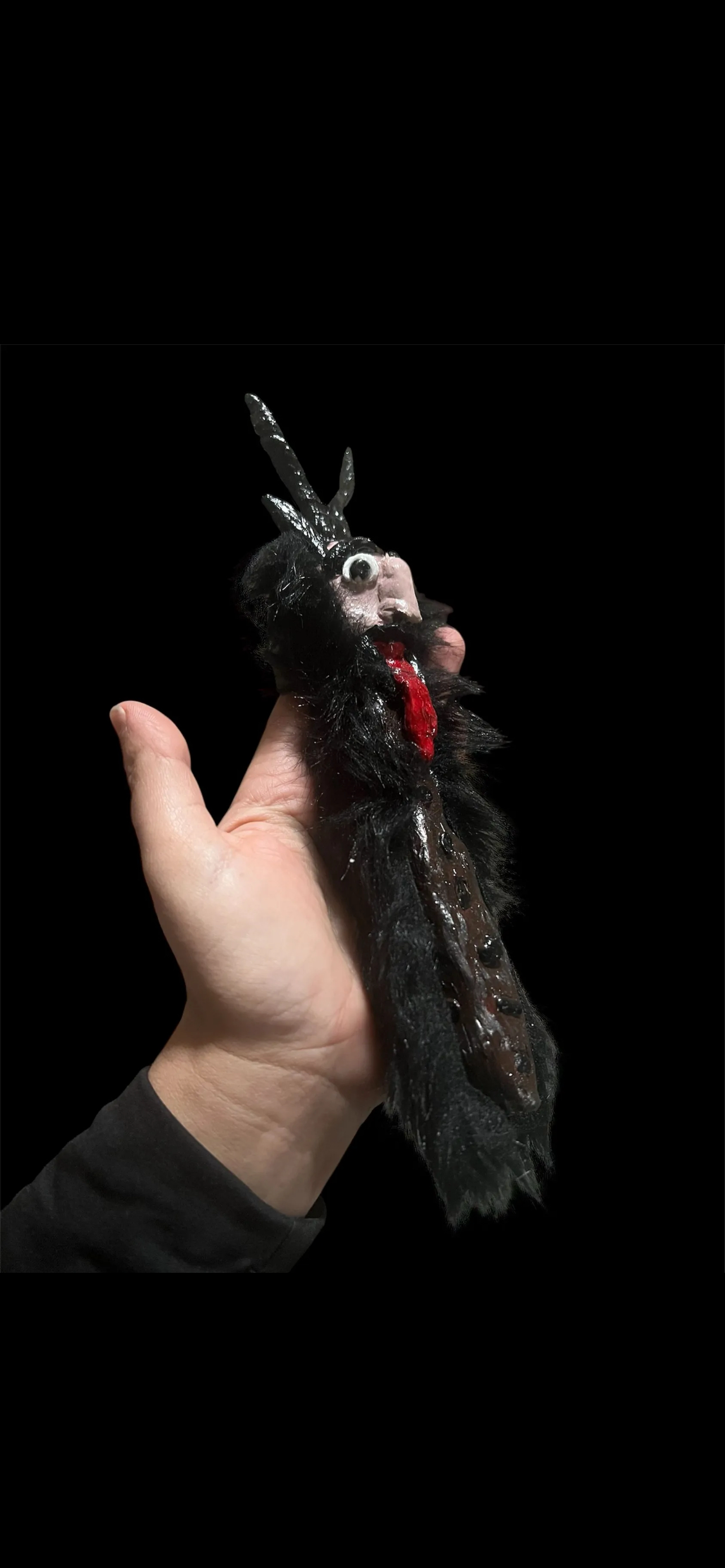 Hand holding a dark, gothic-style wand, krampus folklore