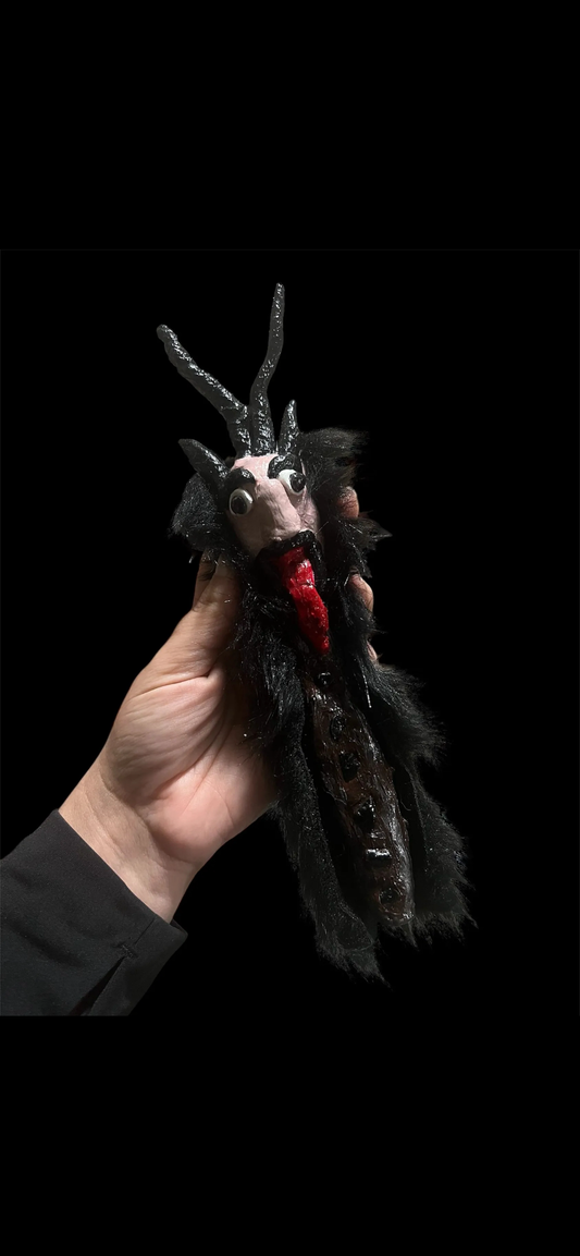 Handcrafted Krampus wand with crystals, dark fur, red accents, and gothic detailing